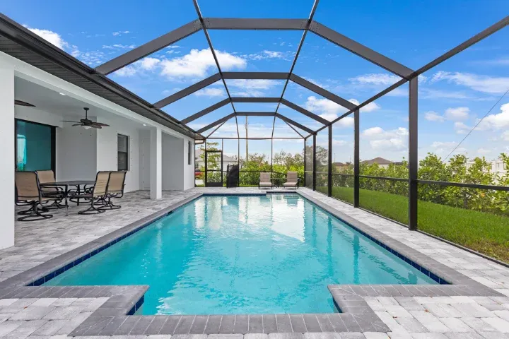 Screened pool enclosure and paver lanai at a Florida home