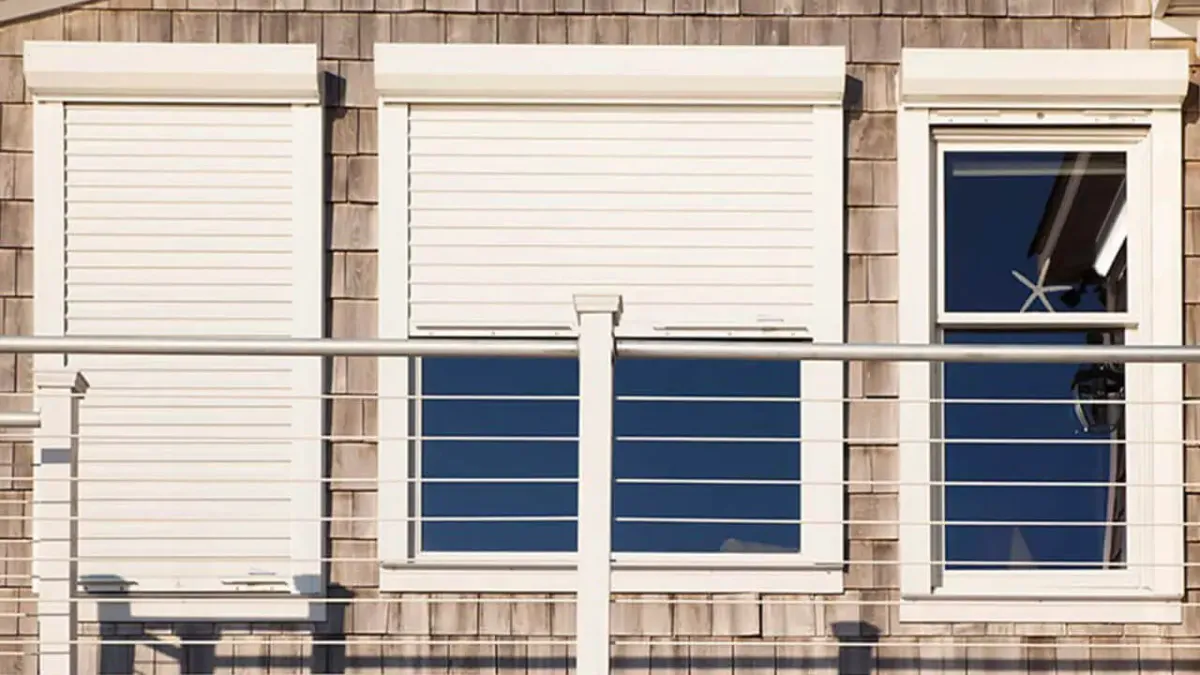 Closed hurricane shutters protecting a home's windows